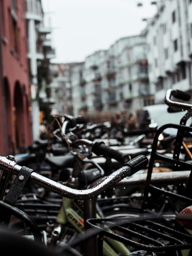 Close-up of parked bicycles in a city with modern buildings and urban design.